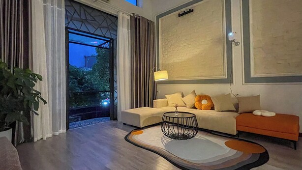 Een moderne woonkamer met een bank, een salontafel en uitzicht op het groen.