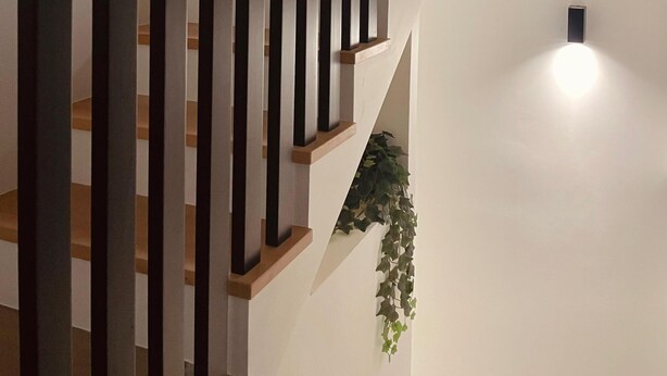 Een moderne trap met houten treden en zwarte verticale leuningen.