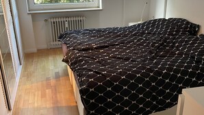 Une chambre à coucher avec un lit, une fenêtre et un radiateur.
