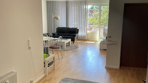 Un vaste espace de vie comprenant un canapé, une table à manger et une grande fenêtre.