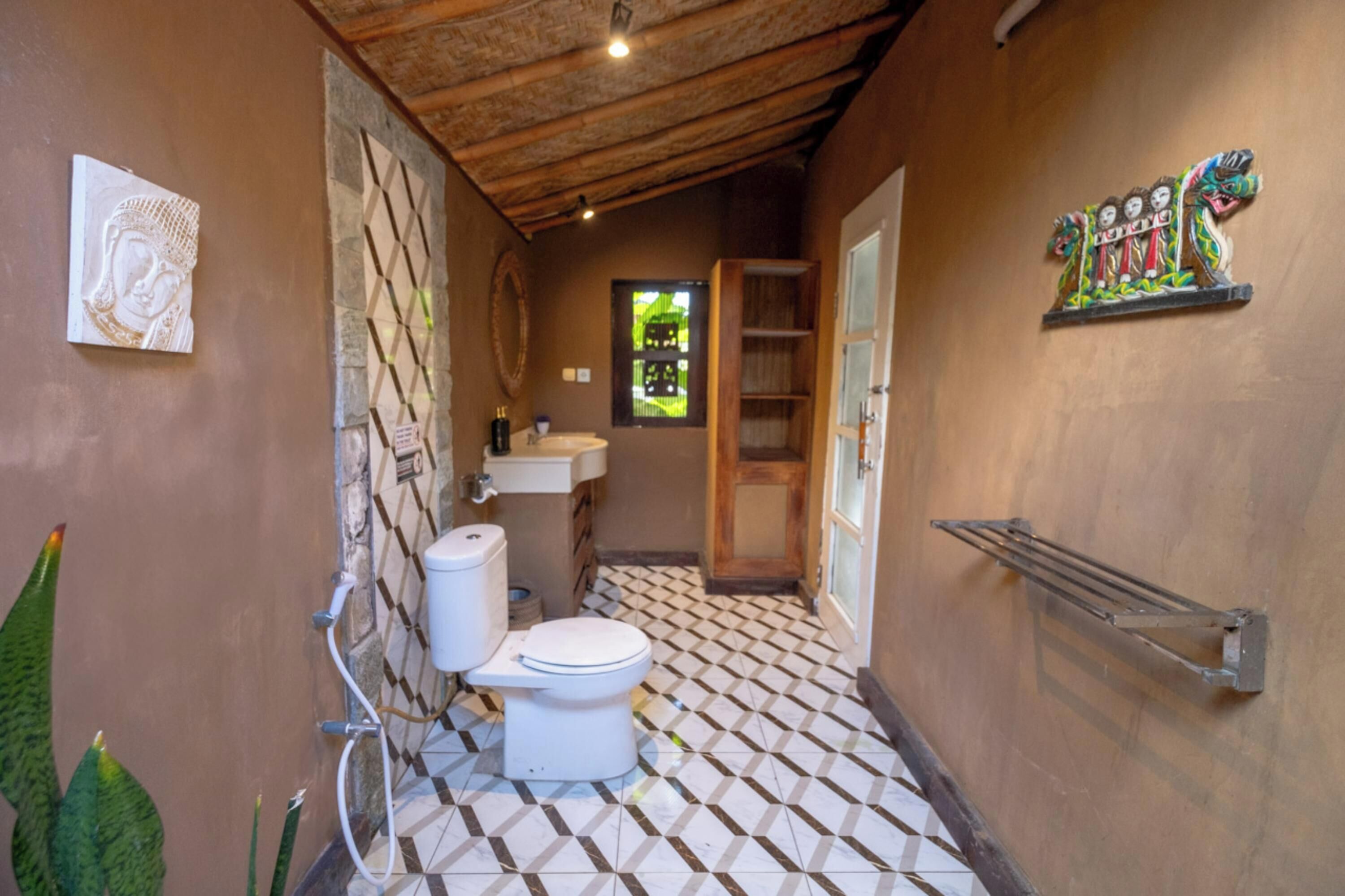 Ein Badezimmer mit gefliestem Boden, Toilette, Waschbecken und Duschbereich.