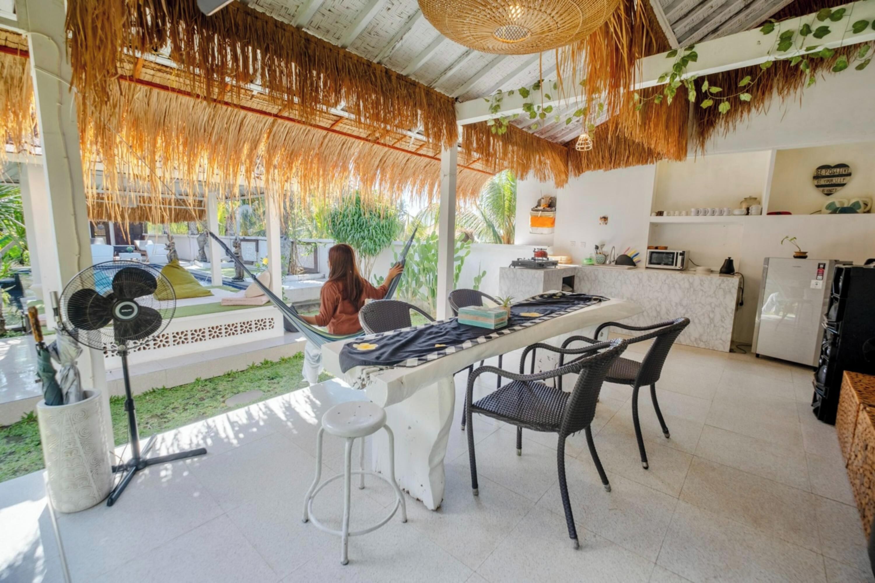 Cocina moderna con comedor, que incluye una mesa grande, sillas, un ventilador y un refrigerador.