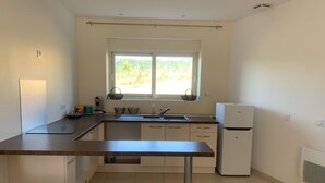 A modern kitchen with a large window, white cabinets, and a white refrigerator. - GITE in the countryside, fully renovated, 30 mn from Lyon, near l'Arbresle (Savigny)