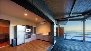 Une cuisine moderne avec vue sur la mer, un plancher en bois et un balcon doté d’une balustrade.