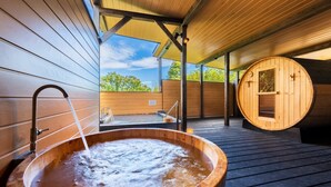 Un espace de bien-être en bois comprenant un jacuzzi et un sauna en bois.