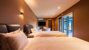 Een moderne hotelkamer met twee bedden, een groot raam en een flatscreen televisie die aan de muur is bevestigd.