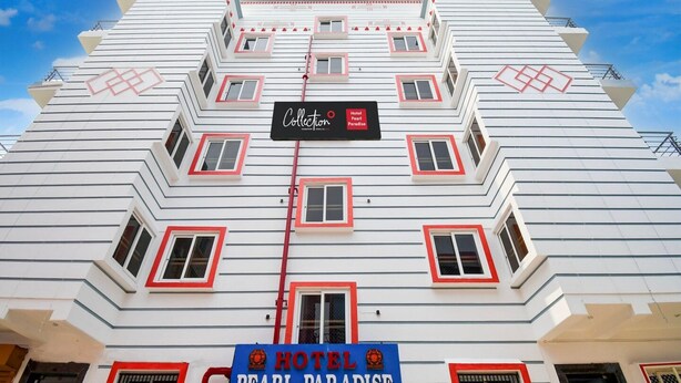A multi-story hotel with a distinctive zigzag facade, multiple balconies, and a prominent sign for 'Hotel Pearl Paradise'. - Collection O Hotel Pearl Paradise (Brahmagiri)