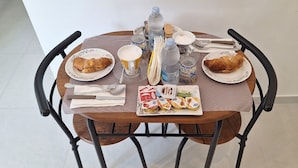 A dining table with plates of food, utensils, and a water bottle. - B&B Santa Maria (Agerola)