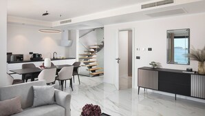 A modern living room with a sofa, coffee table, and a vase of flowers. - Hotel Vallum by St.Pietro (Cavtat)