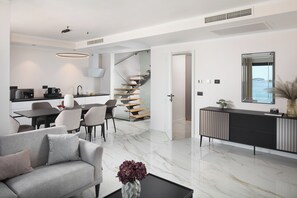 A modern living room with a sofa, coffee table, and a vase of flowers.
