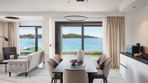 Un comedor moderno con vista al mar, un sofá y una mesa con sillas.