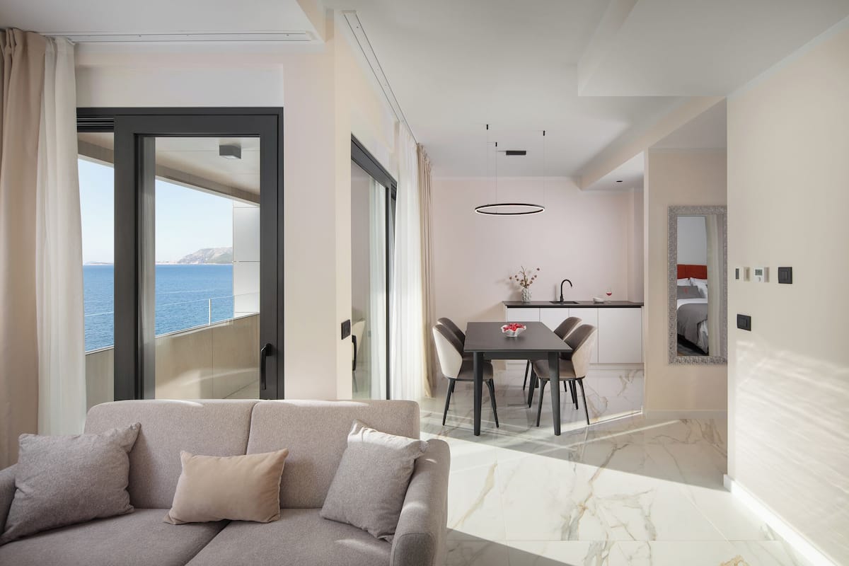 A modern living room with a sofa and a dining area with a table and chairs.