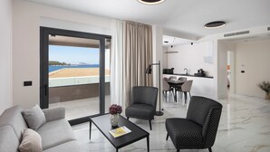 A modern living room with a sofa, armchairs, a coffee table, and a view of the sea through a large window. - Hotel Vallum by St.Pietro (Cavtat)