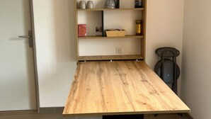Een kamer met een houten tafel en een inbouw wandplank.