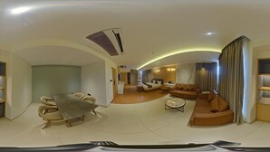 Ein großzügiger Wohnbereich mit gewölbter Decke, einem Esstisch mit Stühlen, einer Couch und einem Couchtisch.