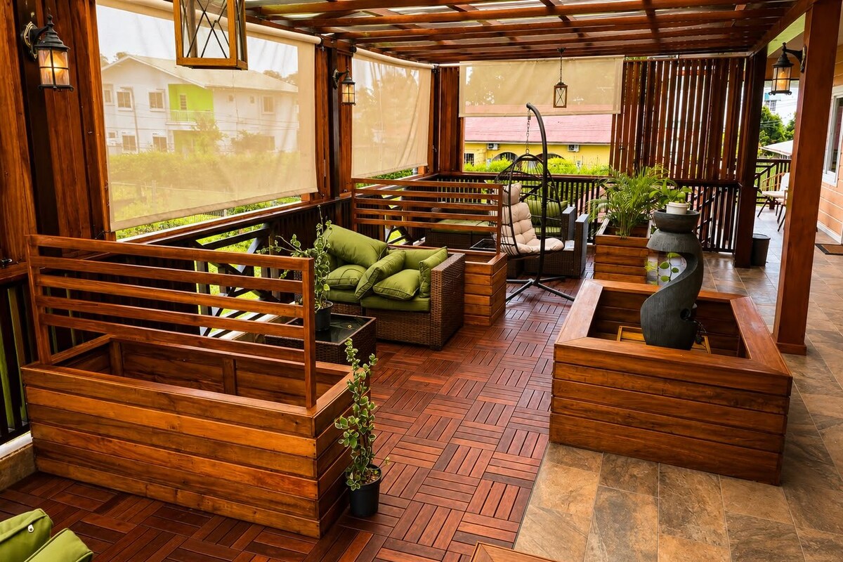Ein überdachter Außenbereich mit Holzmöbeln, Pflanzkübeln und einer Pergola.