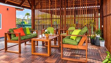 A wooden outdoor seating area with a table and chairs, surrounded by a wooden fence.