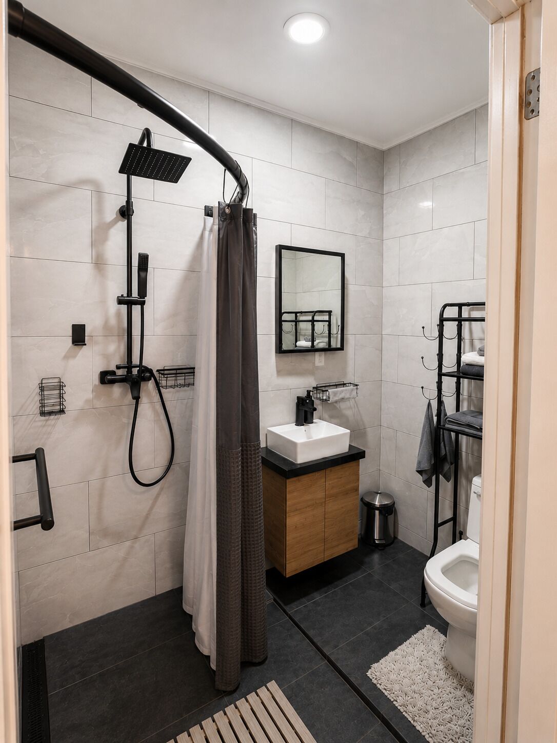 A modern bathroom with a shower, sink, and toilet.