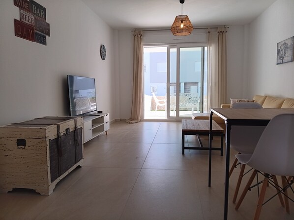 A living room with a TV, a wooden table, and a sofa.
