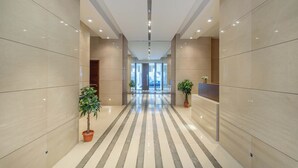 A modern hotel lobby with a striped floor, large windows, and potted plants. - Solidere Lavish Apartments in Downtown Beirut (Beirut)