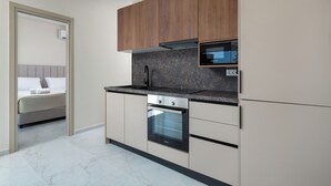 A modern kitchen with a built-in oven, microwave, and a wooden upper cabinet.