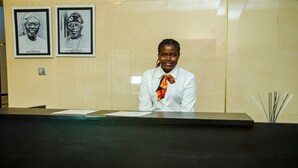 A reception desk with framed portraits on the wall. - Kdovehotels&suites (Lagos)