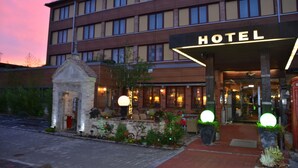 Un hotel con una entrada destacada, un arco de piedra y una fachada bien iluminada.