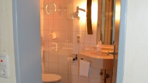 A bathroom with a toilet, sink, and shower. - Gasthaus Gästekiste (Augsburg)