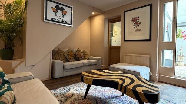 Un salon chaleureux avec un canapé, un tapis à motifs et une table basse originale.