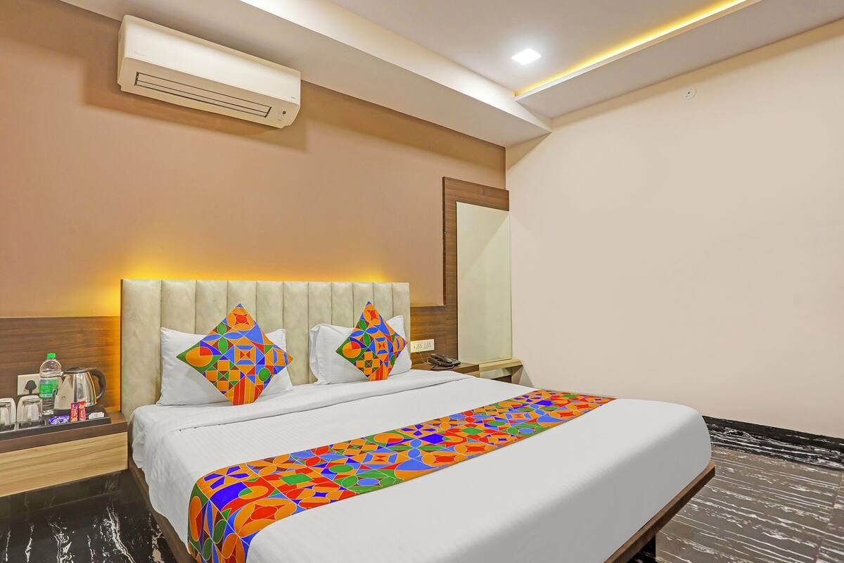 Une chambre d’hôtel équipée d’un lit, d’une table de chevet, d’un miroir et d’un appareil de climatisation.