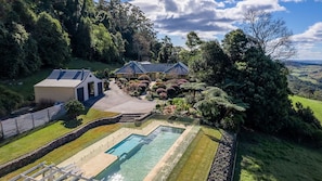 A large estate with a swimming pool, multiple buildings, and a well-maintained garden.