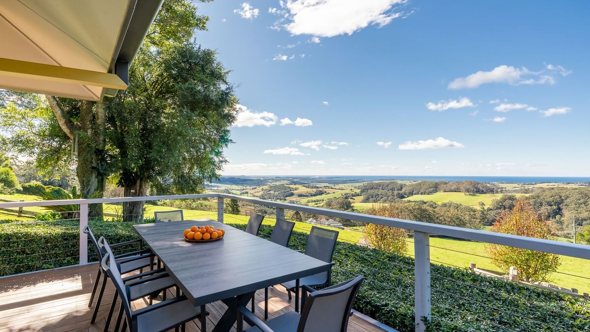 Un área de comedor al aire libre con mesa y sillas, con vistas a un paisaje pintoresco.