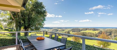 Un área de comedor al aire libre con mesa y sillas, con vistas a un paisaje pintoresco.