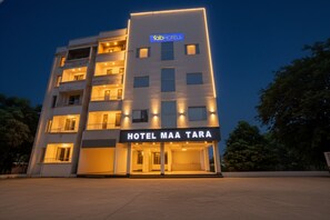 A modern hotel building with a sign reading "HOTEL MAA TARA" and "tabHOTELS" logo.
