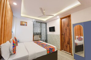 A bedroom with a bed, a ceiling fan, a TV, and a wardrobe. - Via AK Continental (New Delhi)