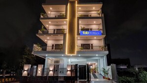 A multi-story hotel with a prominent vertical light feature, balconies with plants, and a sign reading "fabHOTELS". - Fabhotel The Glampoint (Noida)