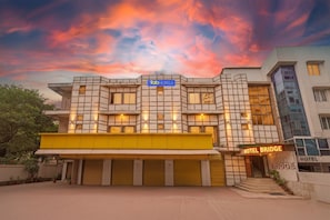 A modern hotel with a grid-patterned facade, multiple balconies, and a prominent 'Tab Hotels' sign.