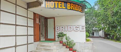 La entrada de un hotel con un cartel que dice "HOTEL BRIDGE" y una escalera que lleva a la puerta.