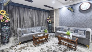 Ein Wohnzimmer mit zwei grauen Sofas, einem Couchtisch und dekorativen Vasen.