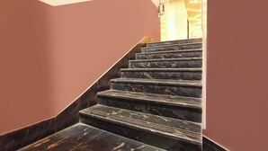 Eine Treppe mit dunklen Marmorstufen, die nach oben führt.