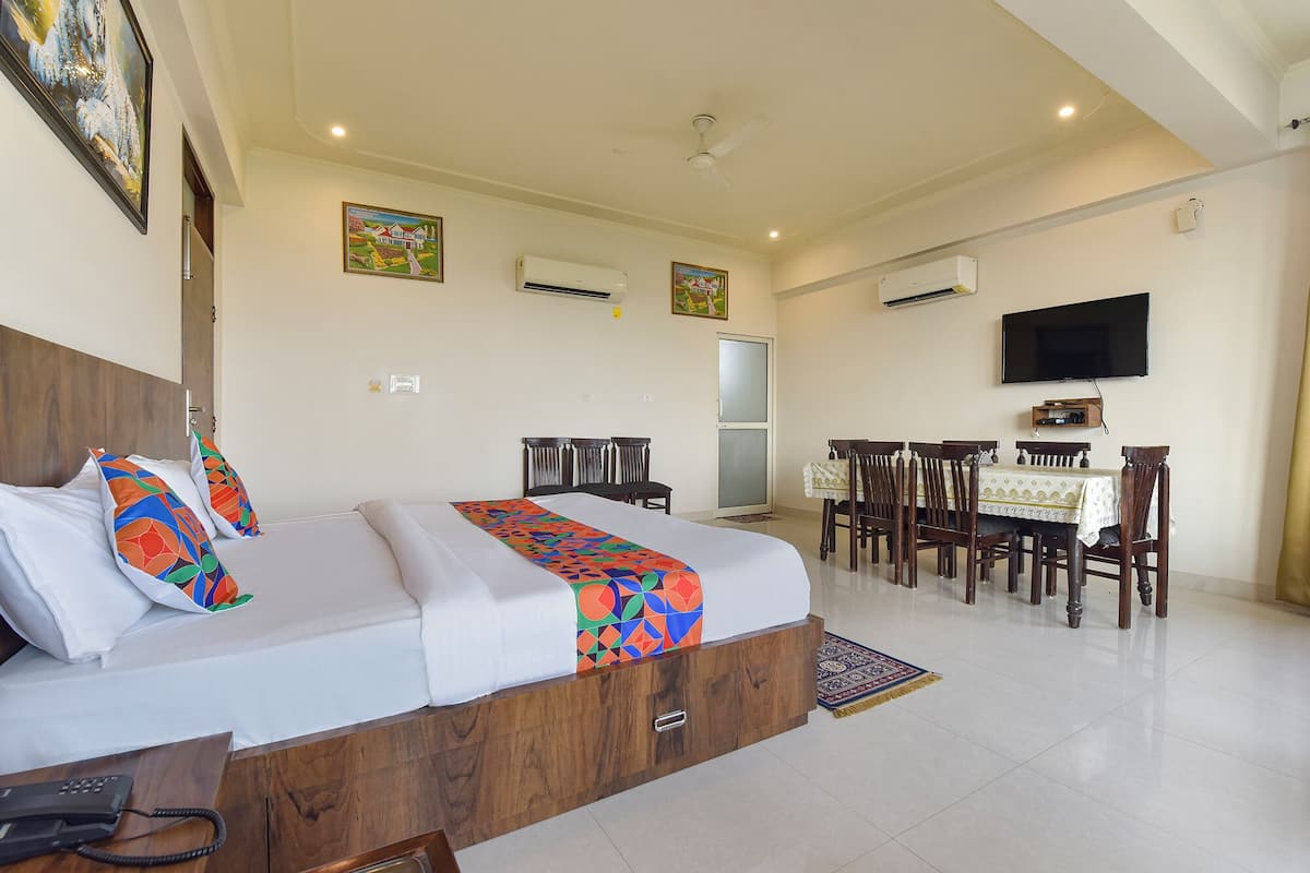 A hotel room with a bed, a desk, and a dining table.
