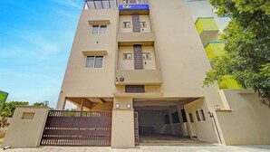 A multi-story hotel with a flat facade, a blue sign reading "fab HOTELS" at the top, and a gated entrance. - Fabhotel Praneeth Residency (Sulur)