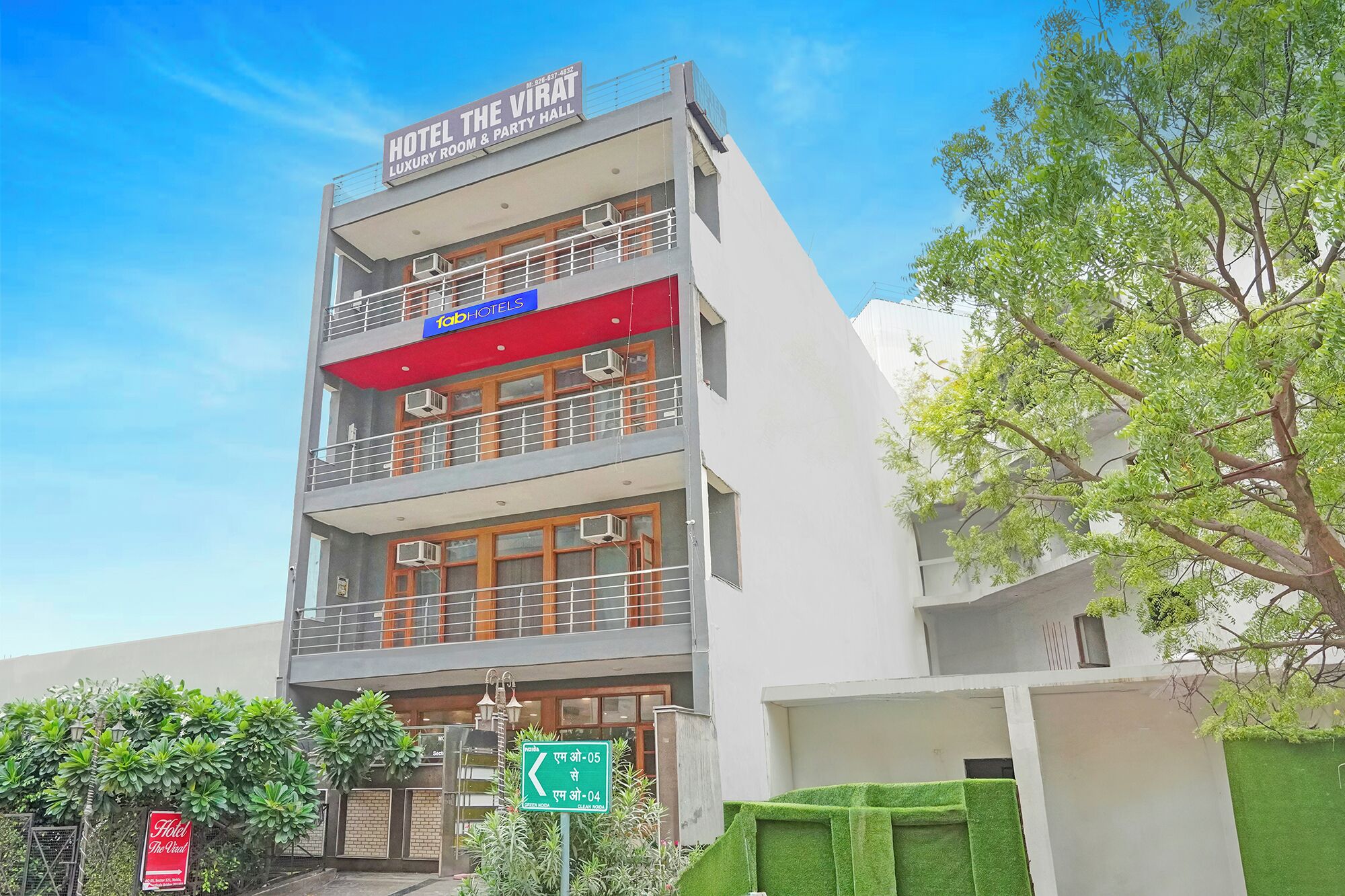 A multi-story hotel with a sign for "Hotel The Virat Luxury Room & Party Hall".