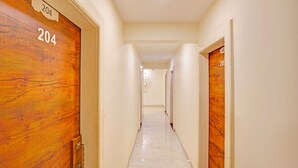 A hallway with wooden doors labeled 204 and 203, leading to rooms. - Fabhotel New Krishna Palace (Indore)