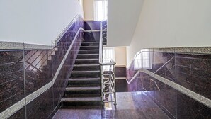 A modern staircase with metal railings and dark marble walls. - Fabhotel Platinum (Bengaluru)