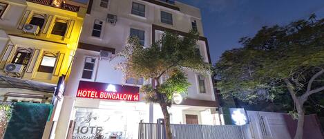 A hotel with a sign reading "HOTEL BUNGALOW 14" and a "Tab Hotels" sign above.