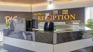 Una recepción de hotel con zona de espera, un cartel que indica 'alquiler de habitaciones' y un reloj que marca las 11 de la mañana.