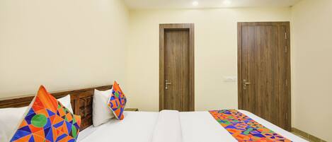 A hotel room with a bed, two doors, and a white ceiling.