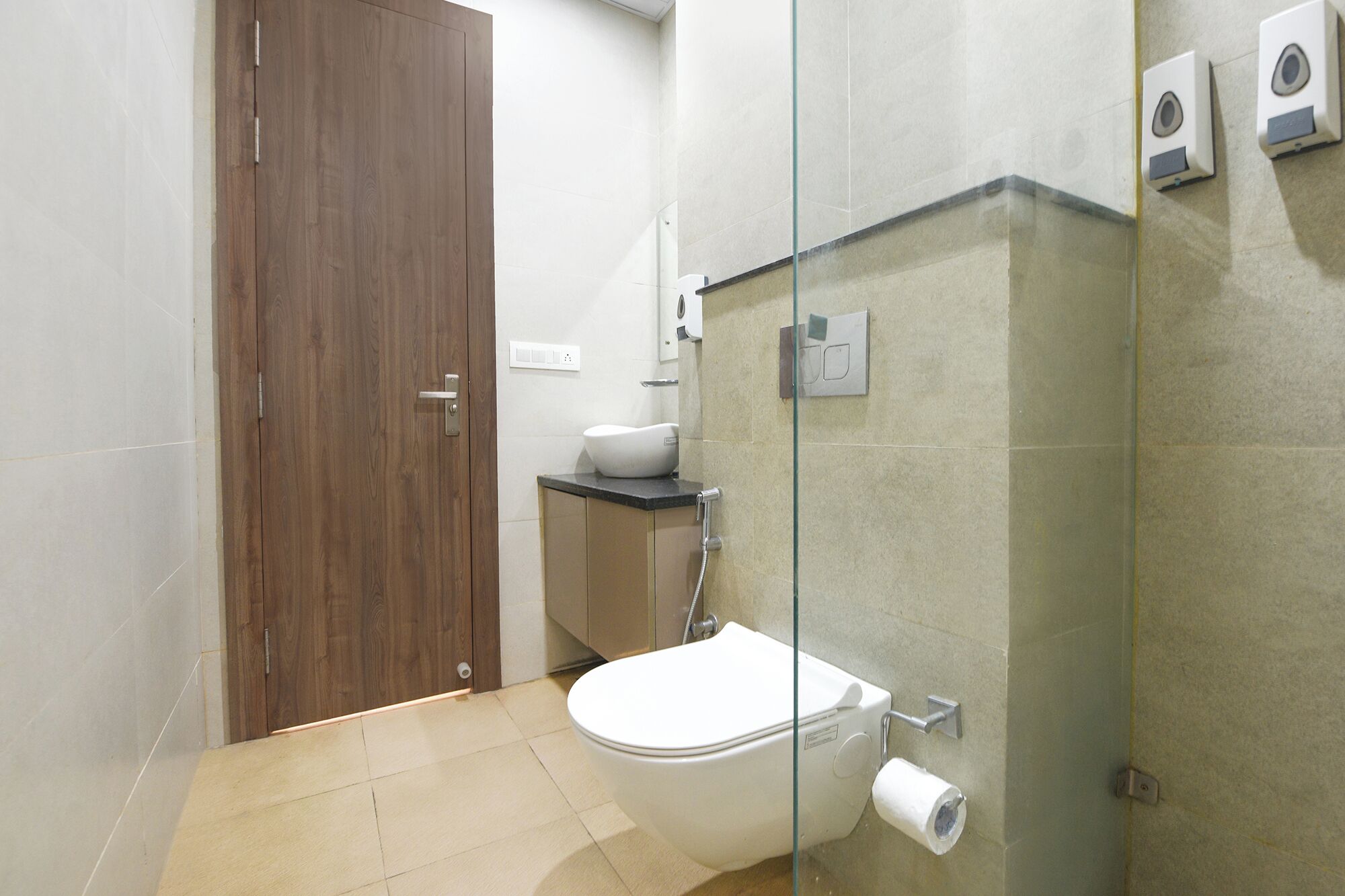 Een badkamer met toilet, wastafel en een douchecabine van glas.