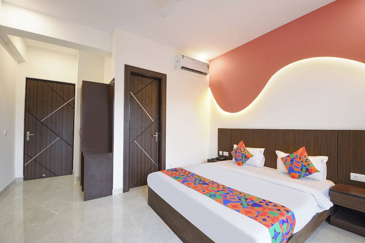 Ein modernes Hotelzimmer mit einem großen Bett, einem Nachttisch und zwei Türen.